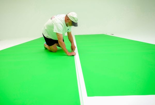 Laying down chroma key flooring in studio